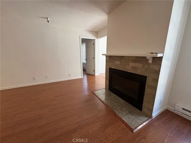 an empty room with wooden floor and fireplace