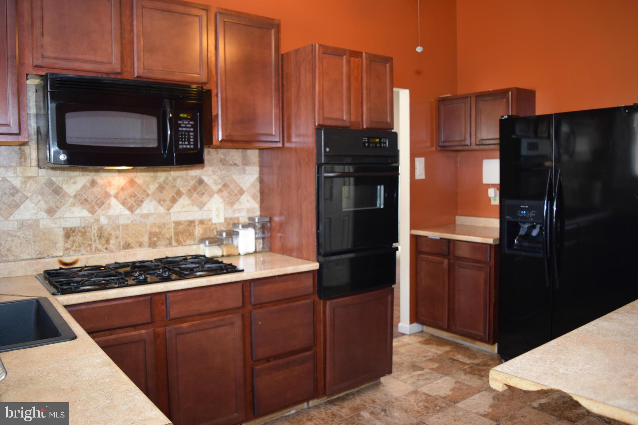 4775 Byron Road Baltimore, MD 21244 - Photo 14 of 29 a kitchen with granite countertop wooden cabinets and stainless steel appliances