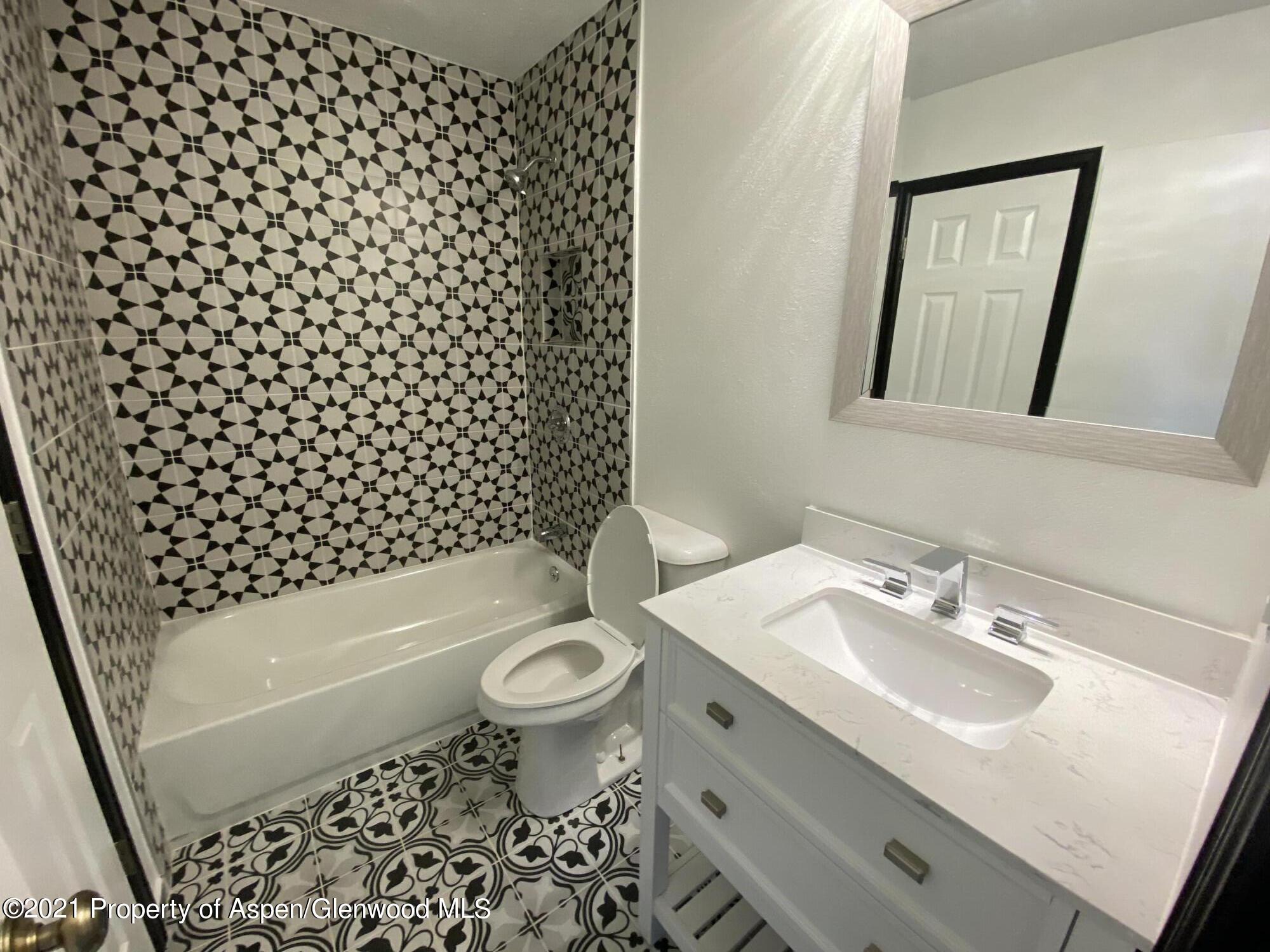 317 Clarkson Avenue Rifle, CO 81650 - Photo 6 of 17 a bathroom with a sink toilet a mirror and shower