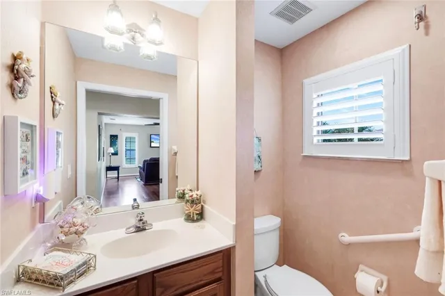 a bathroom with a sink vanity mirror and toilet