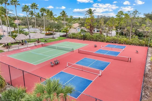a view of a tennis ground with large trees