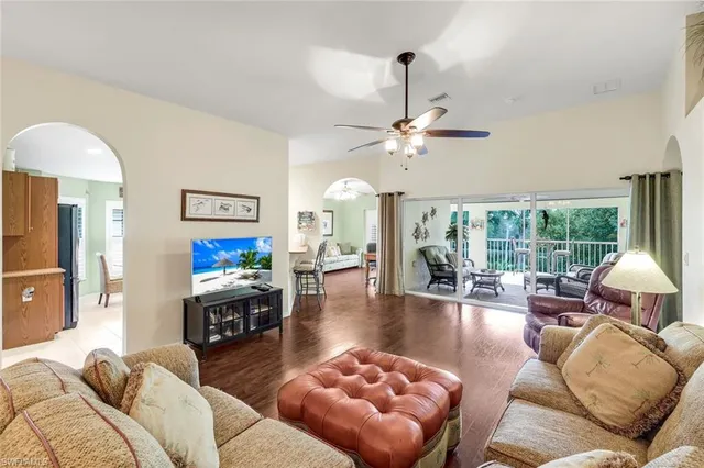 a living room with furniture a chandelier and a floor to ceiling window
