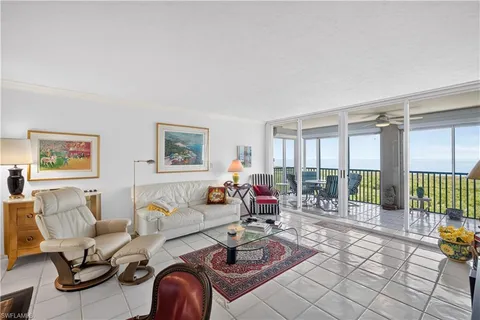 a living room with furniture and a large window with garden view
