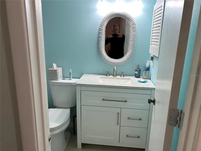 a bathroom with a toilet sink and mirror