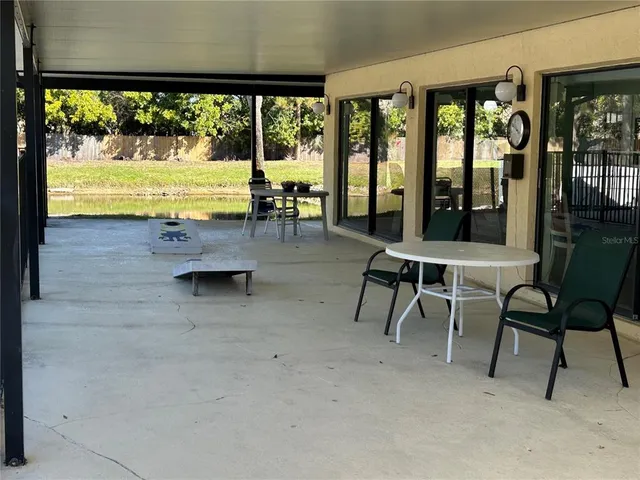 a view of a swimming pool with lawn chairs and couches