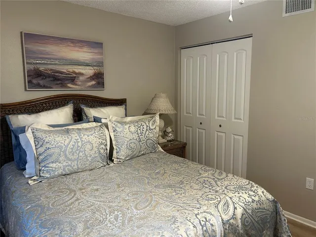 a bedroom with a bed and a painting on the wall