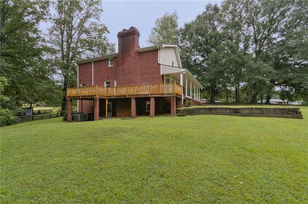 83 Russell Road Lawrenceville, GA 30043 - Photo 58 of 67 a view of a house next to a big yard and large trees