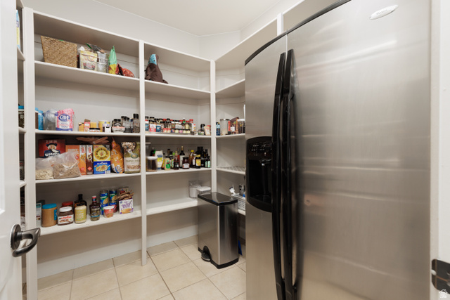 1257 West 2320 South St. George, UT 84770 - Photo 12 of 55 Walk-in pantry featuring extensive white shelving, tile flooring, and a stainless steel side-by-side refrigerator
