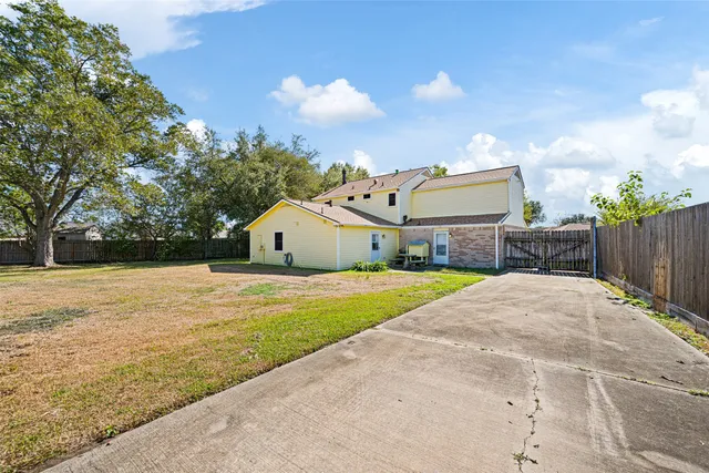 a front view of house with yard and trees in the background