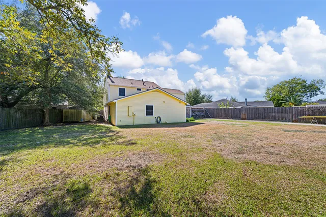 a view of a backyard with wooden fence