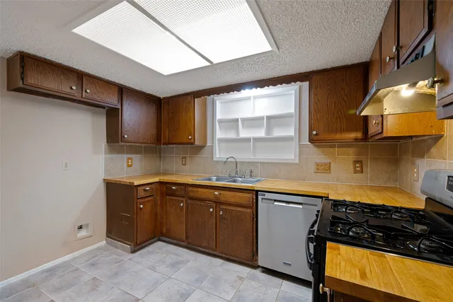 a kitchen with a sink a stove and cabinets