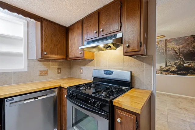 a kitchen with wooden cabinets and a stove top oven
