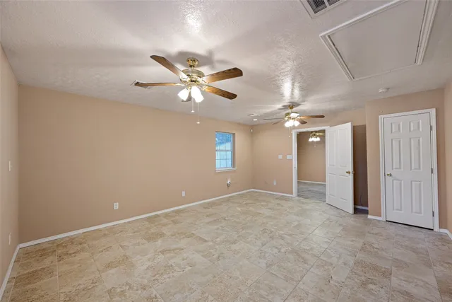 an empty room with a ceiling fan and a window