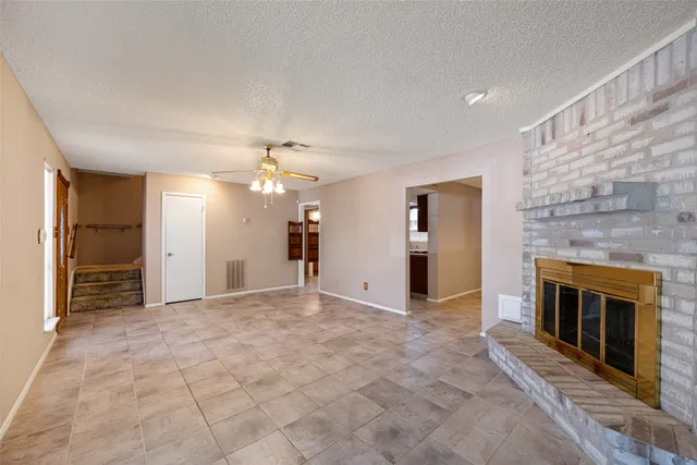 an empty room with windows and a fireplace