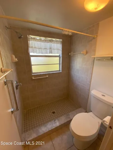 a bathroom with a toilet and a shower