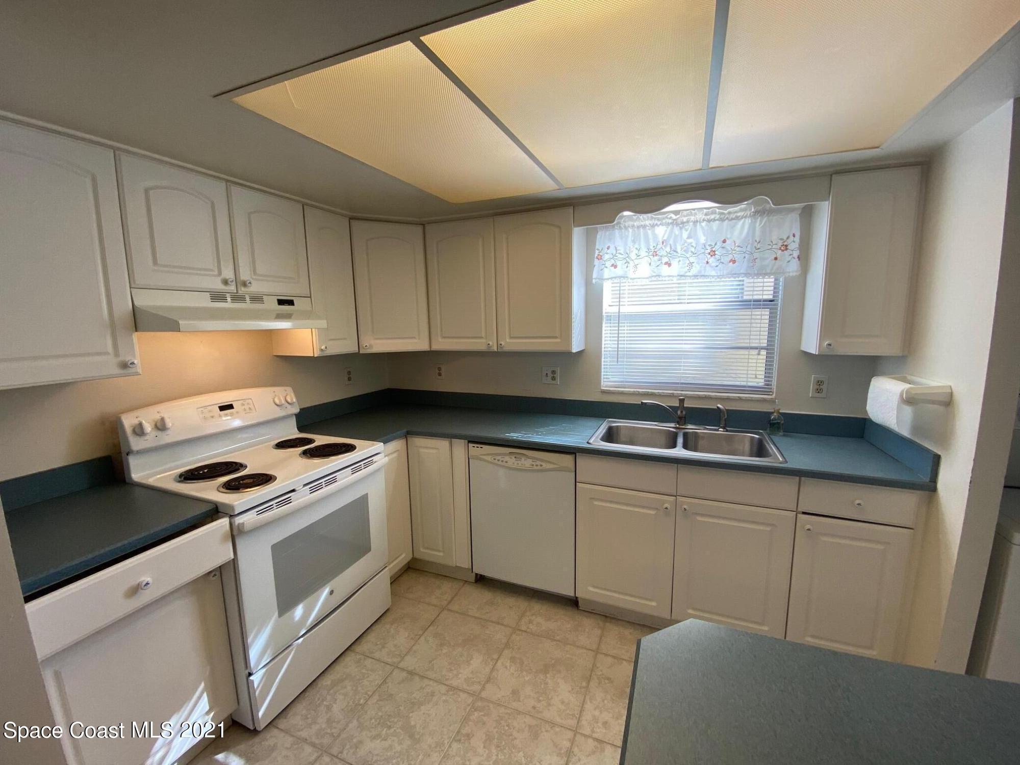 3135 Shady Dell Lane, Unit 112 Melbourne, FL 32935 - Photo 4 of 22 a kitchen with granite countertop white cabinets and white appliances