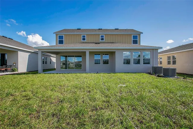 an aerial view of residential houses with outdoor space and ocean view