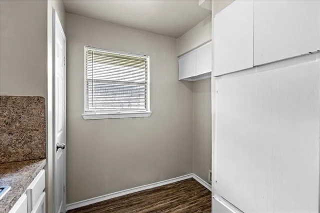 a view of an empty room with closet and a window