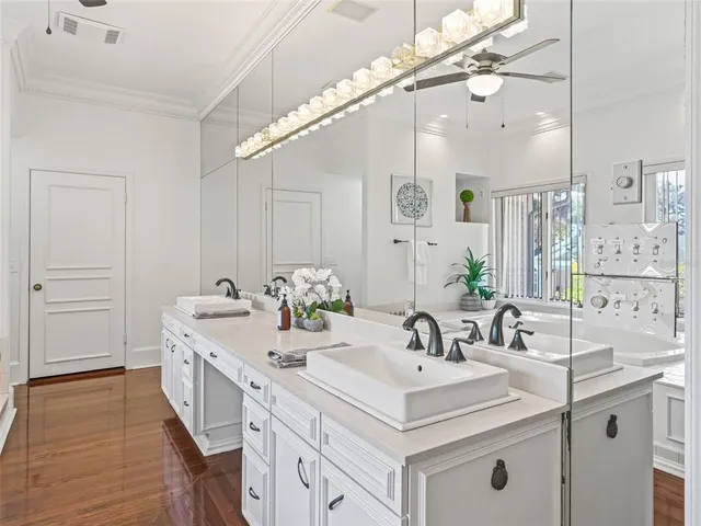 a view of a sink mirror and cabinets