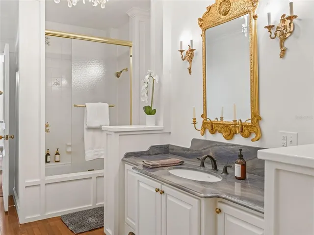 a bathroom with a granite countertop sink and a mirror
