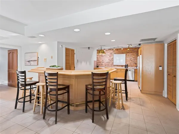 a kitchen with stainless steel appliances kitchen island granite countertop a table and chairs in it