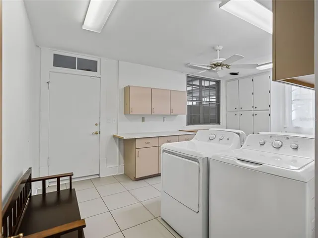 a utility room with cabinets washer and dryer