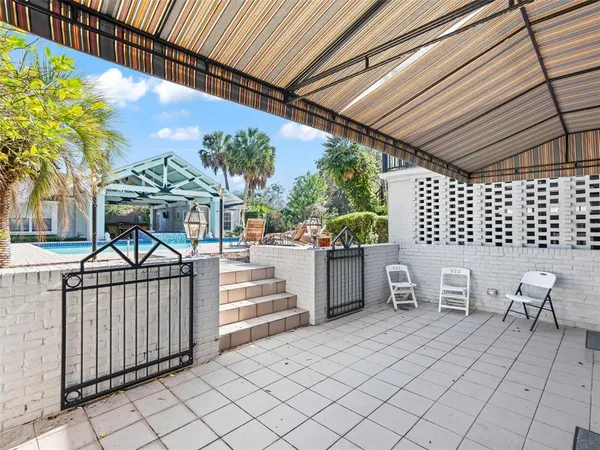 a view of a chairs and table in the back yard of the house
