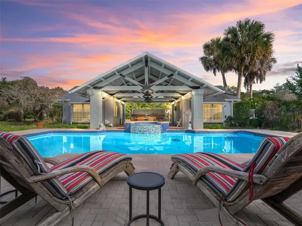 a view of swimming pool with a lounge chair and a small yard