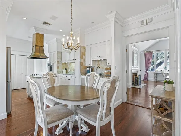 a dining room with furniture a chandelier and wooden floor