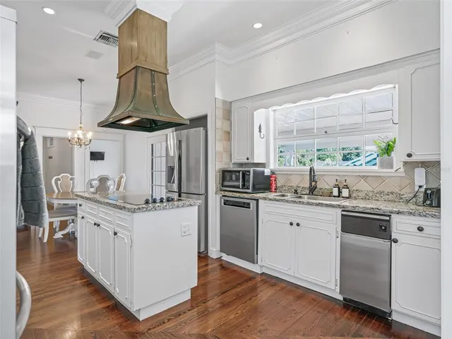 a kitchen with a stove and a wooden floors