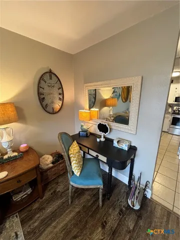 a kitchen with granite countertop a sink a stove top oven and cabinetry
