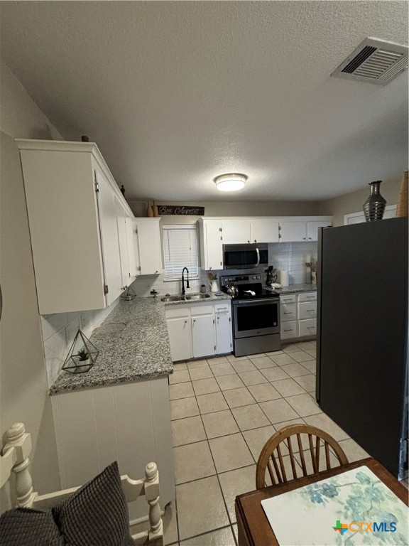 1307 Sherry Lane, Unit B Copperas Cove, TX 76522 - Photo 24 of 48 a kitchen with kitchen island granite countertop a refrigerator and a sink