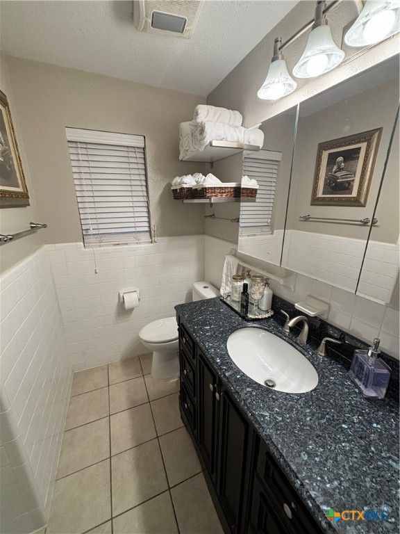 1307 Sherry Lane, Unit B Copperas Cove, TX 76522 - Photo 32 of 48 a bathroom with a granite countertop sink a toilet a mirror and vanity