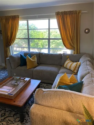 a living room with furniture and a chandelier