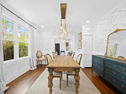 a view of a a dining room with furniture window and wooden floor