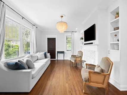 a living room with furniture a flat screen tv and a large window