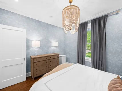 a bedroom with a bed and a chandelier