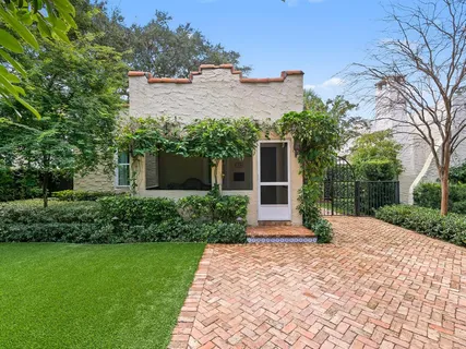 a front view of a house with a yard and trees