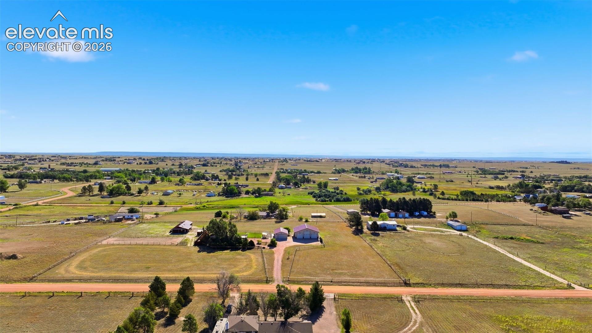 Expansive property featuring multiple structures, open fields, and established tree lines