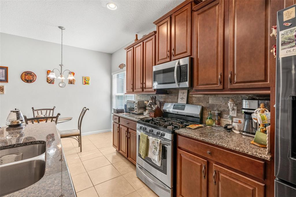 2085 Lula Road Minneola, FL 34715 - Photo 18 of 39 a kitchen with stainless steel appliances granite countertop a stove a sink and a microwave