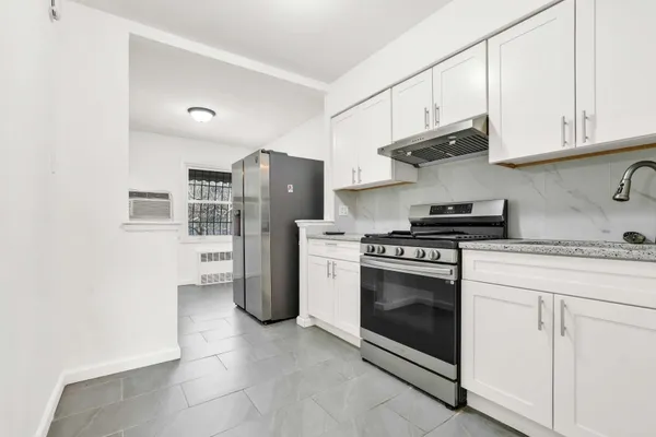 a kitchen with stainless steel appliances granite countertop a stove a refrigerator and cabinets
