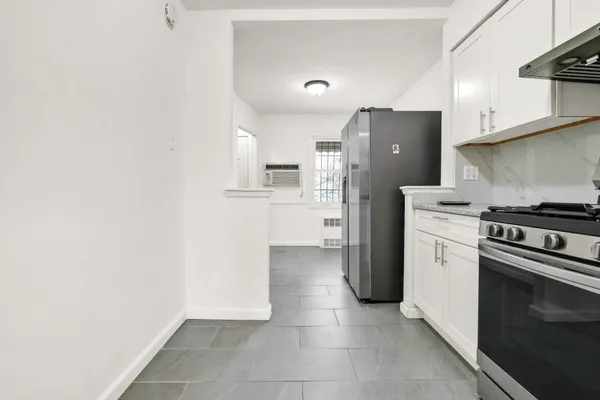 a kitchen with a refrigerator and a stove top oven