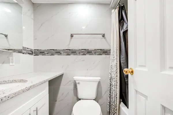 a bathroom with a granite countertop sink toilet and shower