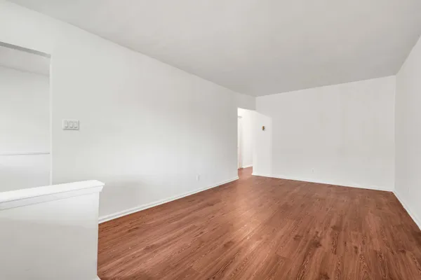 a view of a room with wooden floor and white walls