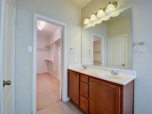 a view of an empty room and chandelier fan