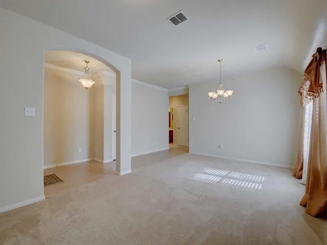 an empty room with a fireplace and a chandelier fan