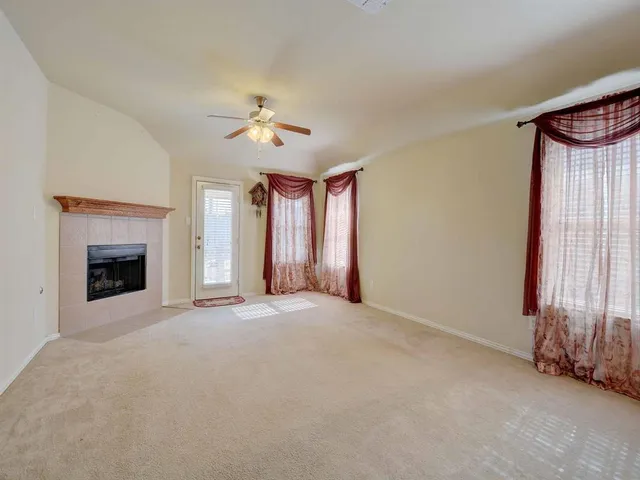 a view of an empty room with a fireplace and a window