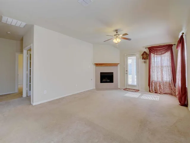an empty room with closet and a chandelier fan