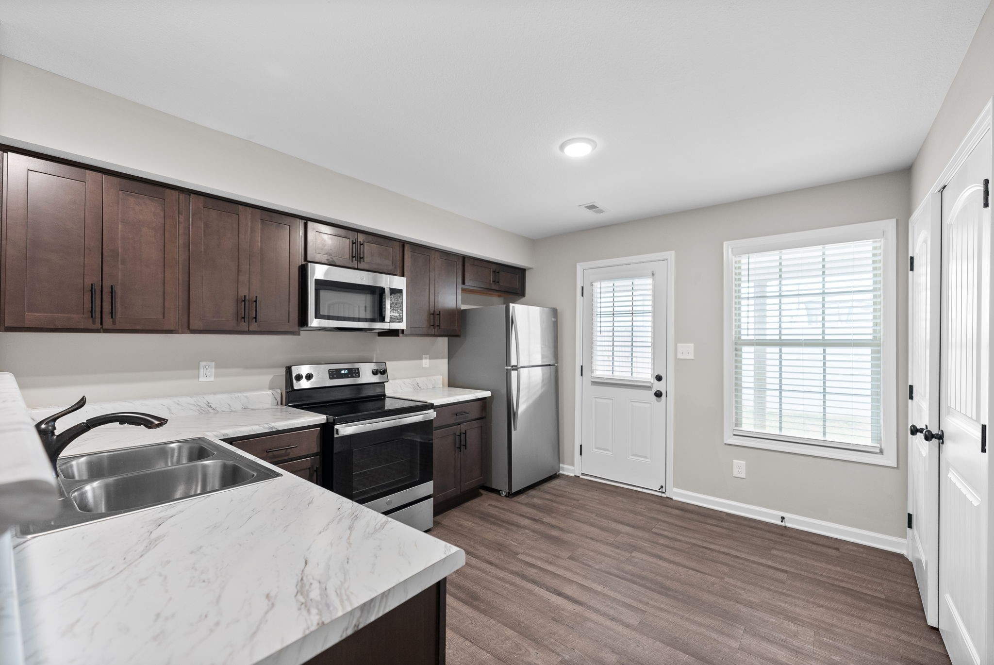 418 Peachers Mill Road, Unit G2 Clarksville, TN 37042 - Photo 7 of 21 a kitchen with stainless steel appliances granite countertop a sink a stove a refrigerator cabinets and wooden floor