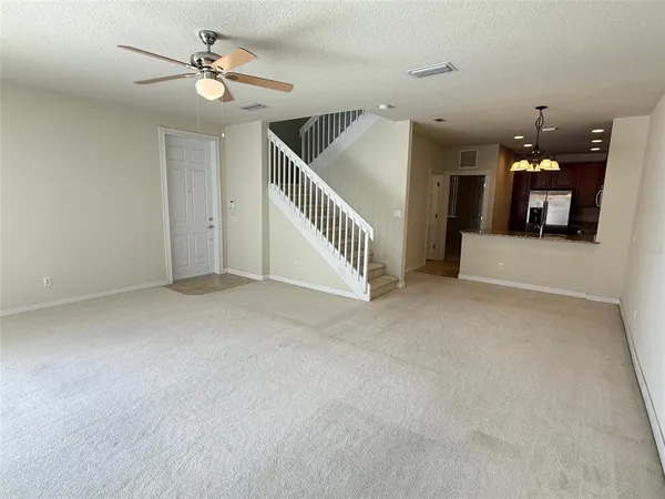 a view of a livingroom with a ceiling fan stairs and a chandelier fan